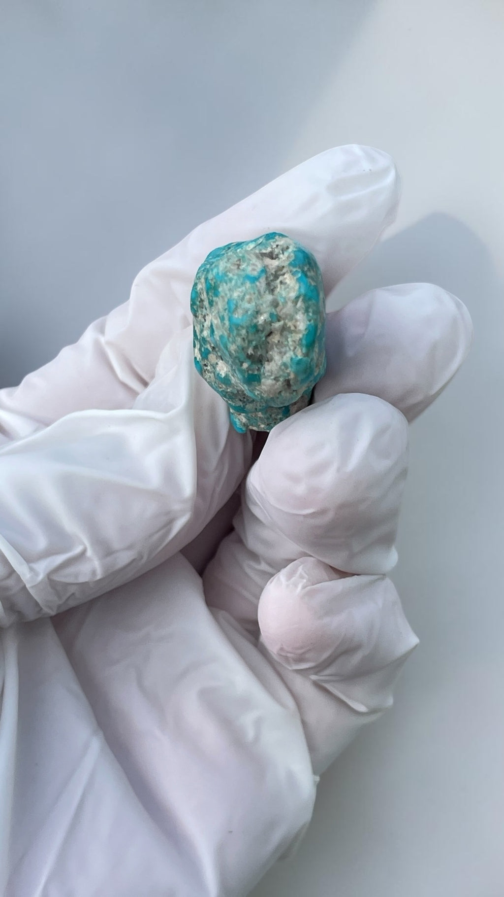 Back view of polished turquoise specimen showing natural matrix and blue coloration